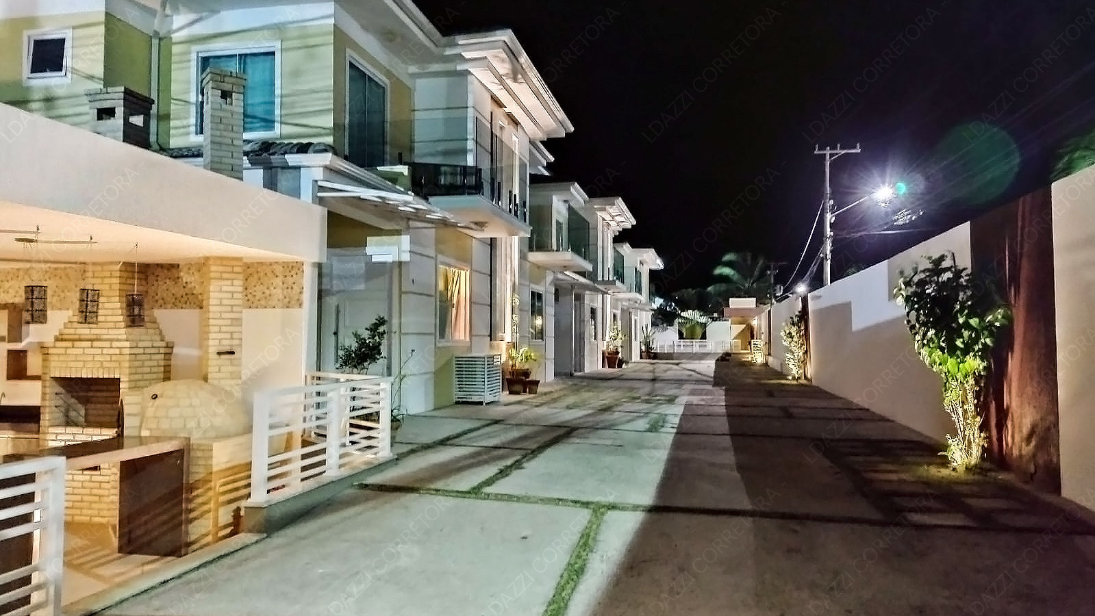 Fachadas iluminadas e área de convivência noturna do Condomínio Aurum Pescatore