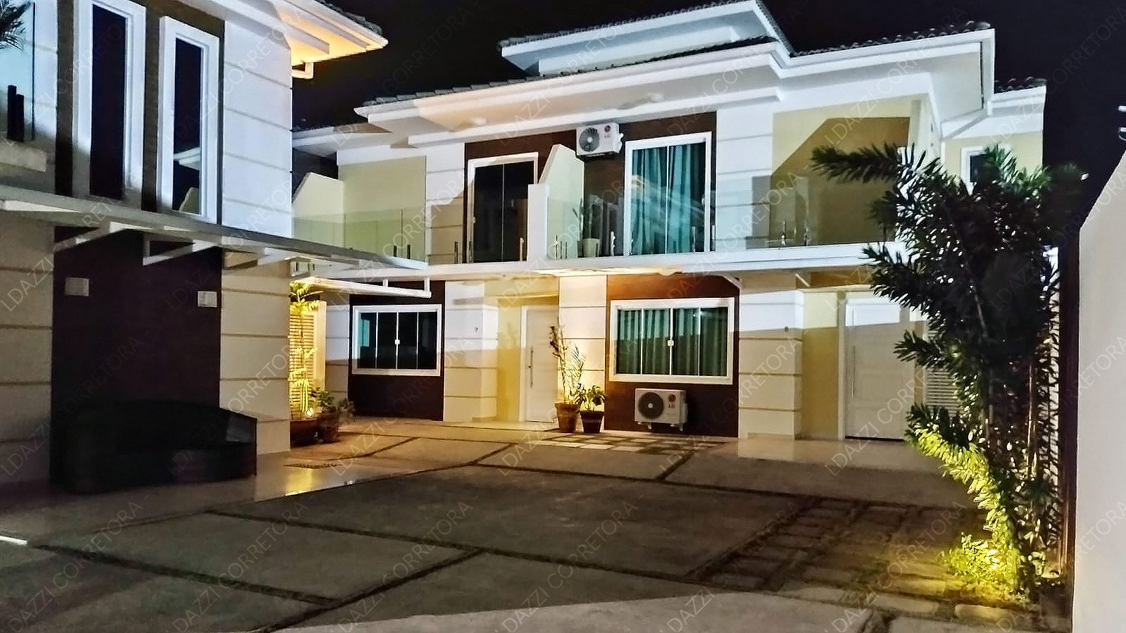 Fachadas iluminadas e área de convivência noturna do Condomínio Aurum Pescatore